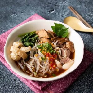 Small bowls of noodles in a dark, tasty and a little bit spicy broth. T