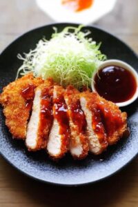 A thick pork cutlet with breadcrumbs and deep-fried until golden and crisp outside, juicy inside.